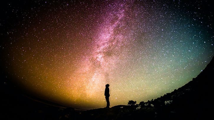 silhouette at the center of a starry universe