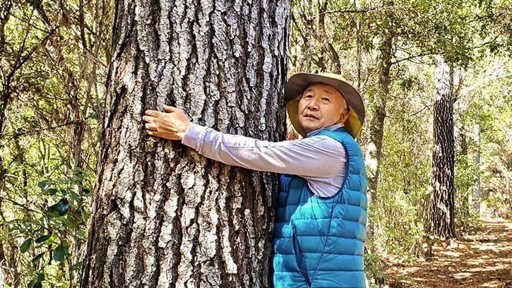 Ilchi Lee hugging a tree