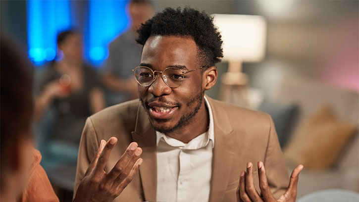 young black man speaking with a smile and gesturing with his hands
